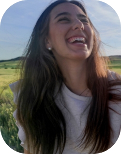 Chica riéndose con un paisaje campestre de fondo